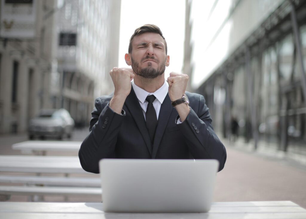 Confident businessman in Budapest celebrates success with a fist pump, reflecting a professional achievement.